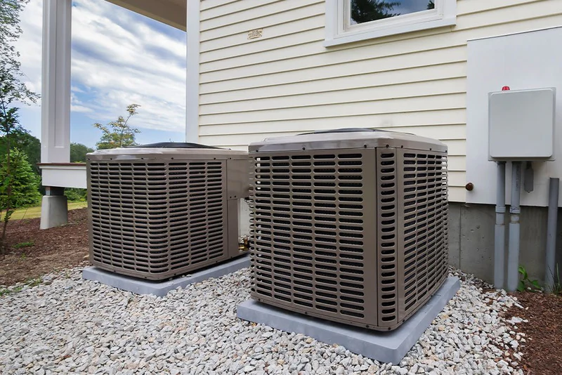 Two residential HVAC condenser units installed beside a Chester County home